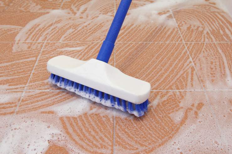 Spazzolone che pulisce una superficie esterna insaponata