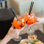Due persone che brindano con calici aperitivo