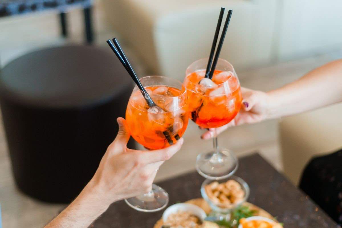 Due persone che brindano con calici aperitivo