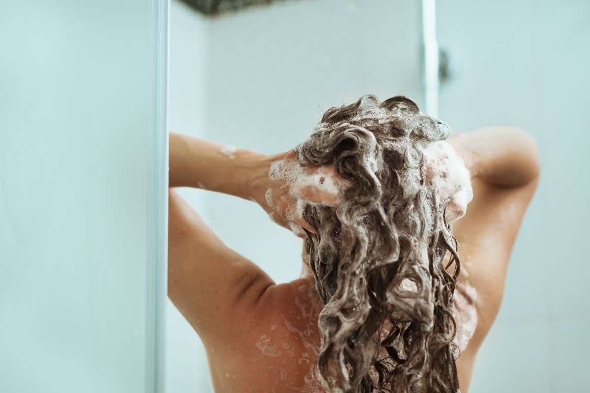 Donna che fa lo shampoo
