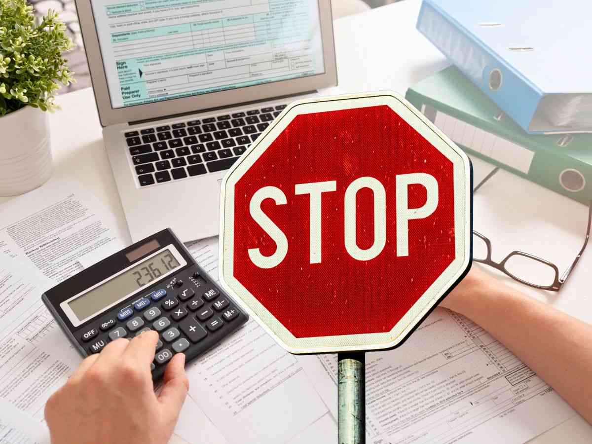 sfondo persona fa calcoli al pc e cartello STOP