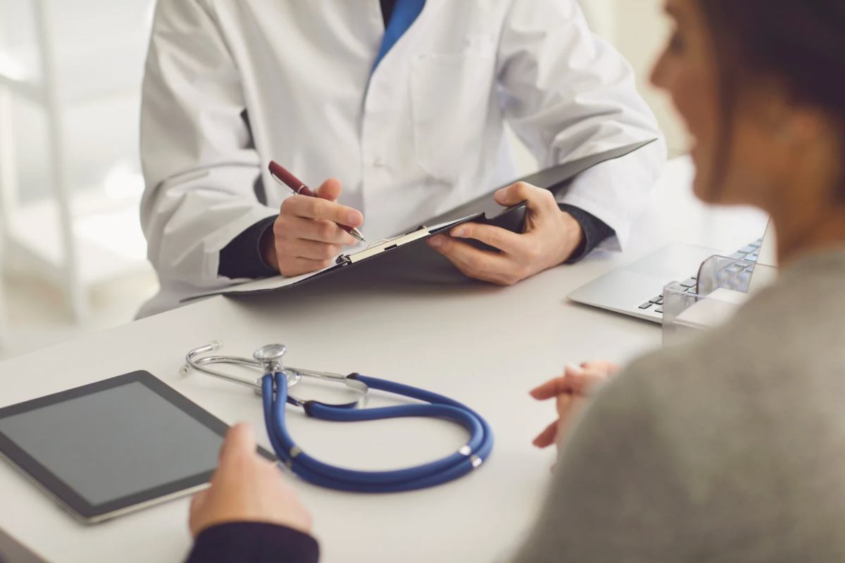 Medico che scrive sulla cartellina e paziente